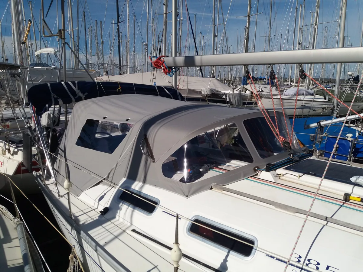 Sailing yacht in a marina with the cockpit fully enclosed