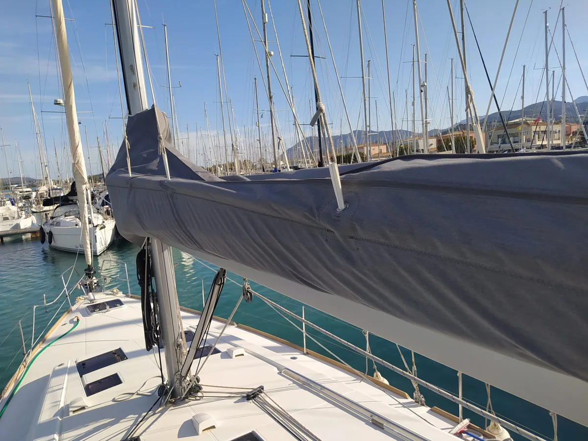 Navy lazy bag closed along the boom of a yacht, marina in the background