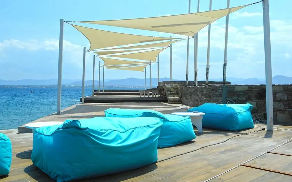 Shade sails over a seaside terrace at a coastal hotel