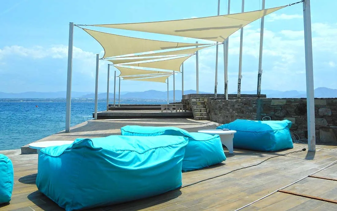 Shade sails over a seaside terrace at a coastal hotel