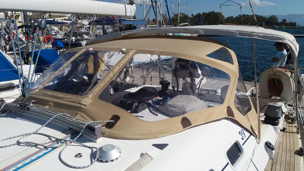 Tan sprayhood with a bimini behind it on a yacht at its berth