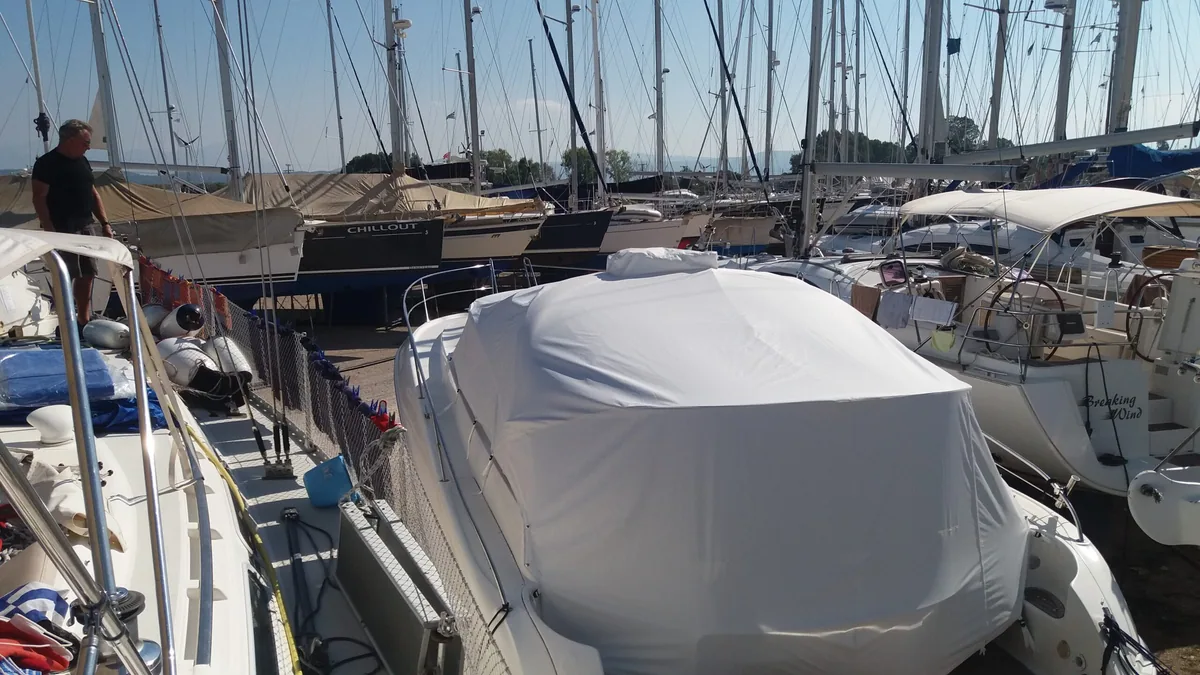 White cover shielding the cockpit of a yacht moored between others