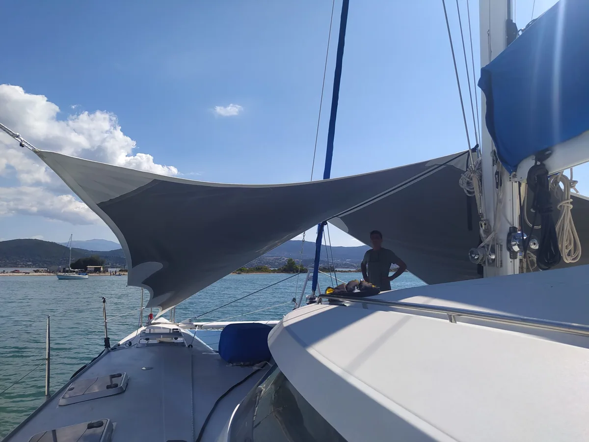Grey shade sail rigged over the foredeck of a yacht, open sea behind