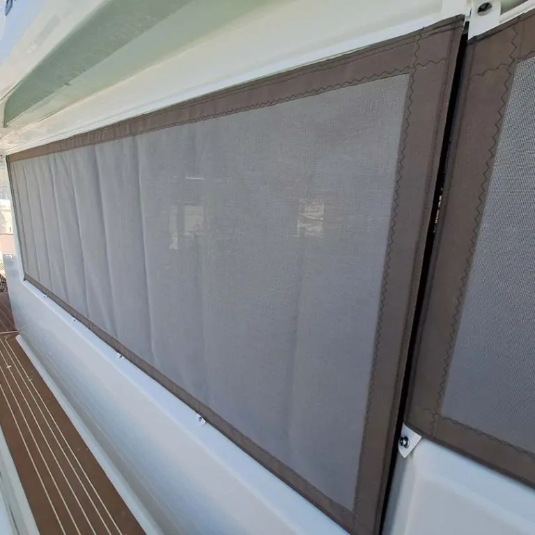 Window blind fitted along a cabin window above the teak side deck