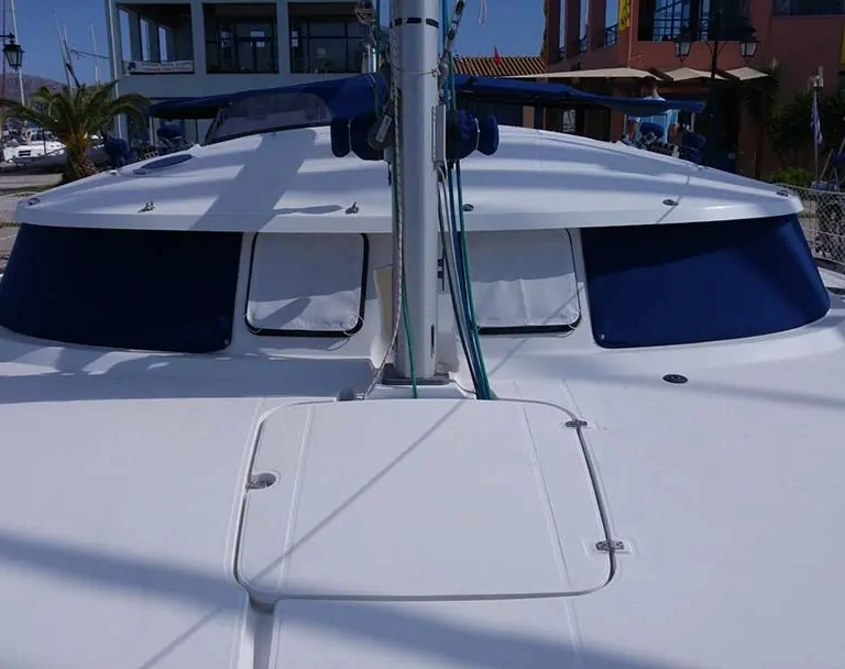 Blue covers over the windows and foredeck hatches of a catamaran