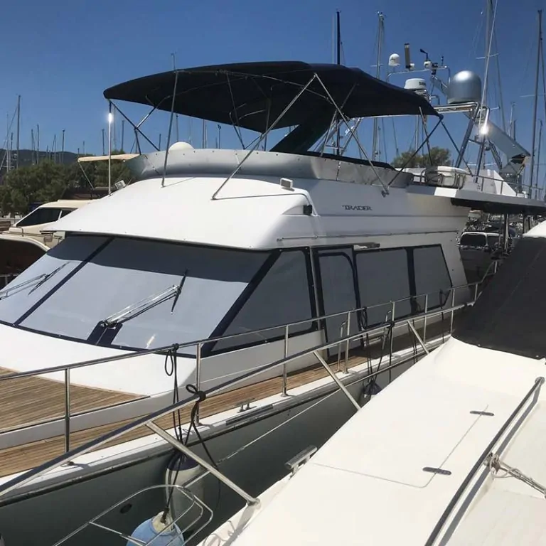 Motor yacht at its berth with covers on the flybridge windows