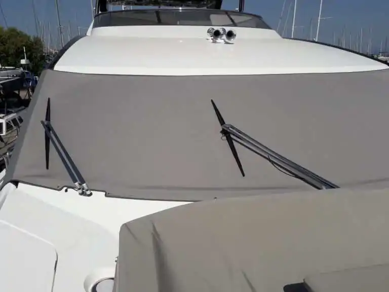 Grey cover fitted over the windscreen of a motor yacht