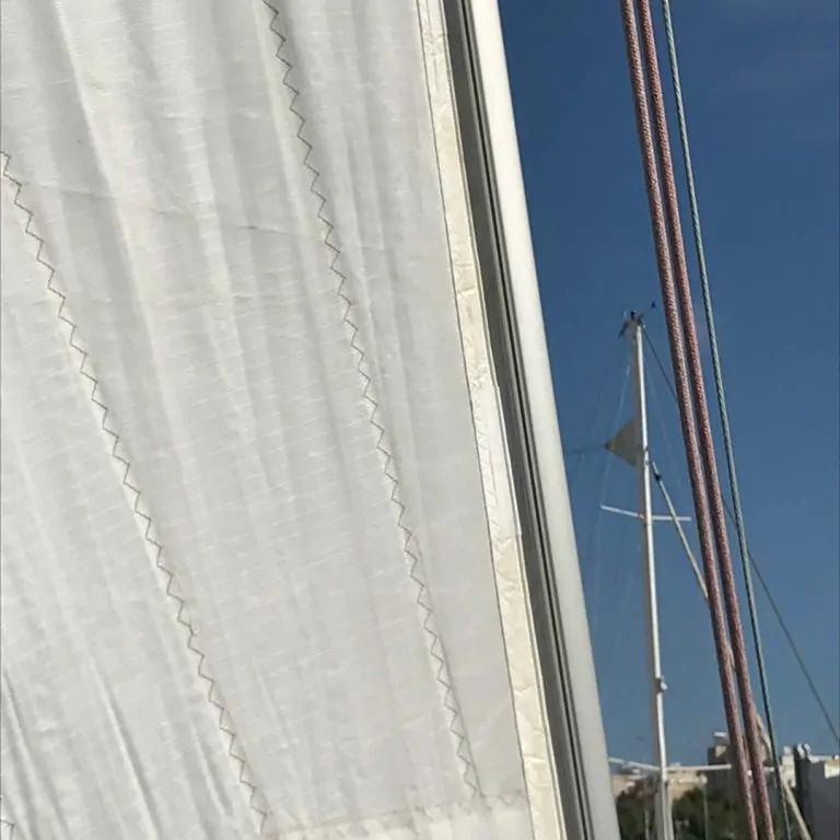 Stitched canvas hanging beside the mast of a boat in a marina