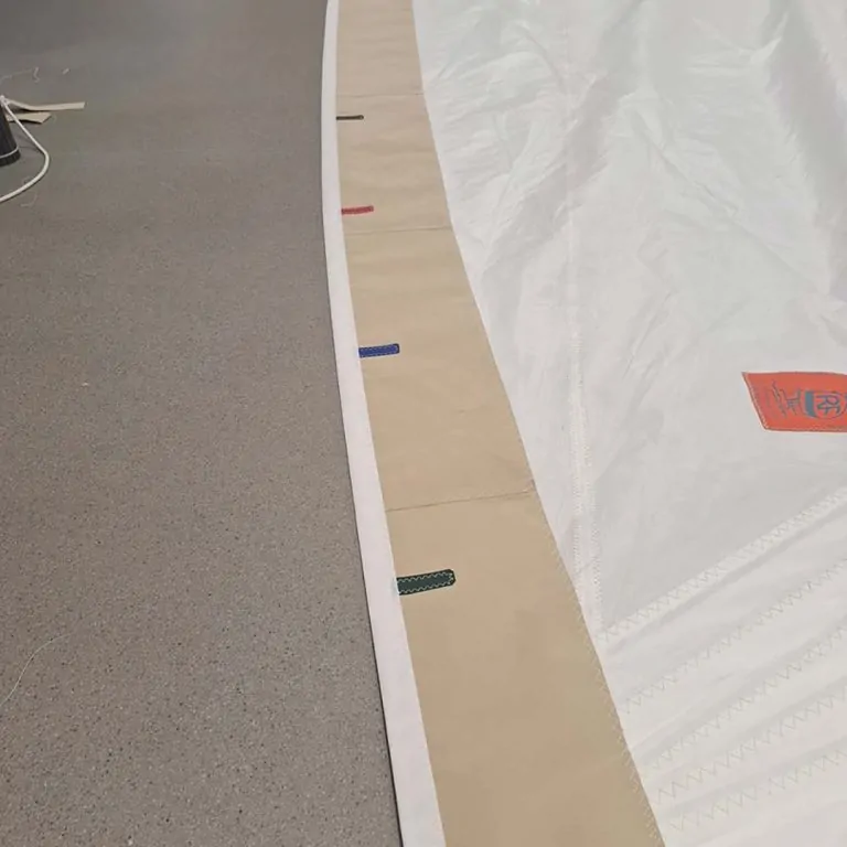 Curved bound edge of a panel, with fixing tabs along the hem