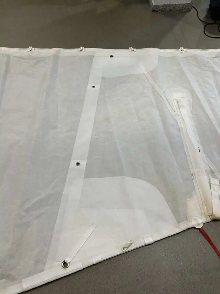 Panel spread out on the workshop floor with its seams and eyelets visible