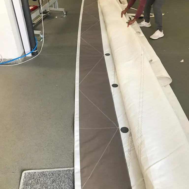 Rolled canvas being carried through the workshop